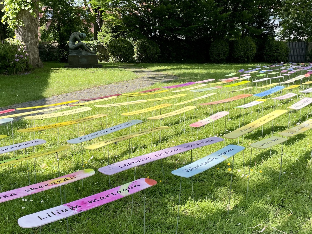 Ines Hock,  BE(E) HERE eine Installation im öffentlichen Raum  zwischen  Wilhelm-Morgner Museum und der Nikolaikapelle, Soest. 2022. Die farbigen Tafeln, die sich im Wind wie Blumen bewegen, zeigen die Blütenfarben der Pflanzen, die auf der roten Liste NRW stehen und vom Aussterben bedroht sind. Die Blühpflanzen sind Lebensgrundlage für unsere Insekten.